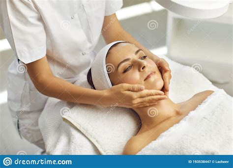 Spa Facial Massage Beautician Makes Face Massage To Woman In White