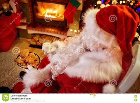 Santa Claus Relaxing At Home With Milk And Fresh Cookies Stock Photo