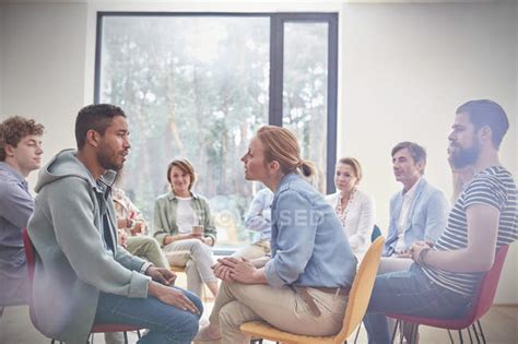 Group Watching Man And Woman Talking Face To Face In Group Therapy Session — Caucasian Self