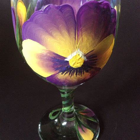 A Purple And Yellow Flower Sitting In A Wine Glass