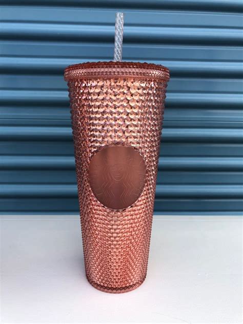 A Copper Colored Cup With A Straw In It