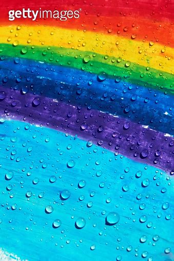 A rainbow drawn with crayons and raindrops falling on it 이미지