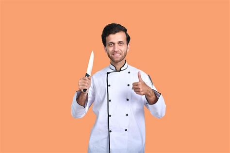 Premium Photo Handsome Chef Cook White Outfit Holding Knife Indian Pakistani Model