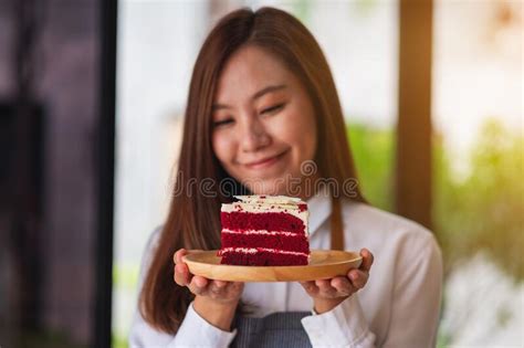 A Beautiful Young Asian Woman Holding And Eating A Piece Of Red Velvet Cake In Wooden Tray Stock