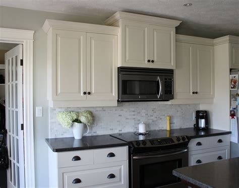 Cabinets can be sprayed in place or uninstalled, whichever is more convenient. Dark cabinets white backsplash | Hawk Haven