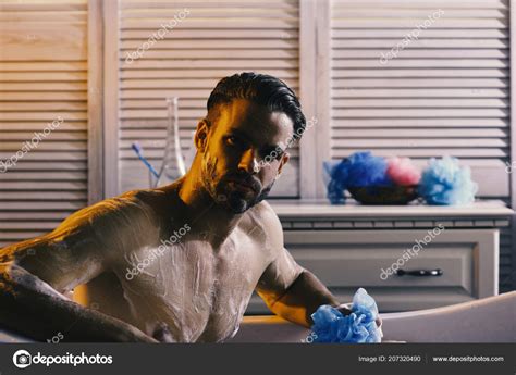 macho sitting naked in bathtub selective focus guy in bathroom covered with foam selective