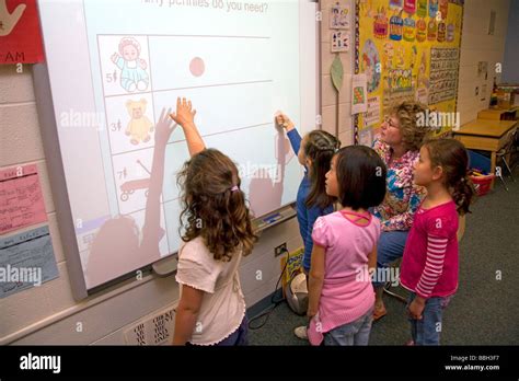 Kindergarten Students Use An Interactive Whiteboard In The Classroom Of