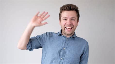 European Young Man Waves His Hand Greets His Friends Stock Image
