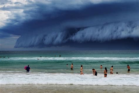 Startled Beachgoers Stand And Watch The Tsunami Cloud Roll Over The