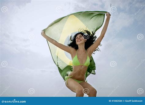 Menina Atrativa Nova Que Salta Com A Bandeira De Brasil No Ar Foto De Stock Imagem De