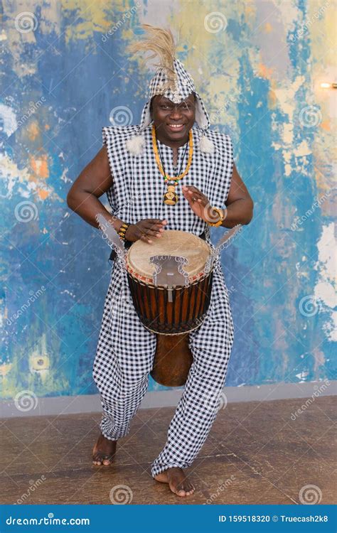 African Artist In Traditional Clothes Playing Djembe Drum Stock Photo