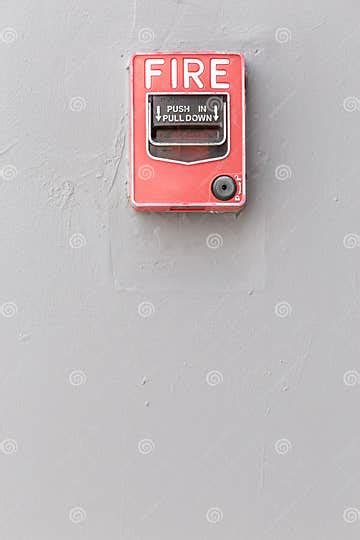 Red Fire Alarm Switch On Exterior Cement Wall Of Commercial Building