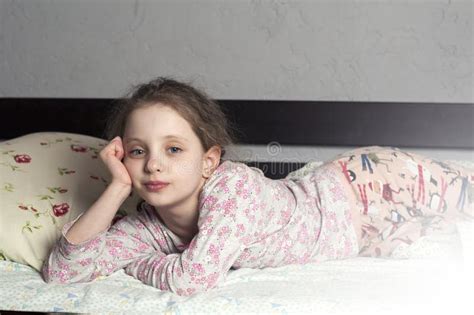 The Girl Is A European 10 Years Old Lies In His Pajamas On The Bed In