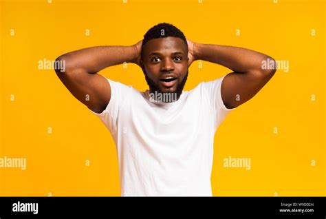 Amazed African Man Holding Hands Behind Head Stock Photo Alamy