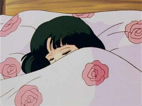 A Person Laying In Bed Under A Blanket With Pink Flowers On It