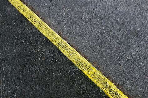 Painted Yellow Curb Separating Sidewalk And Street By Stocksy
