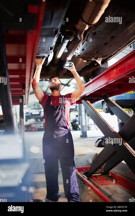 Male Mechanic Working Under Car In Auto Repair Shop Stock Photo Alamy