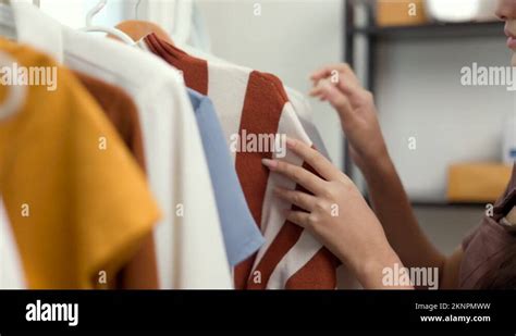 Close Up Female Hands Choosing Many Clothes On The Rail Hanging Woman