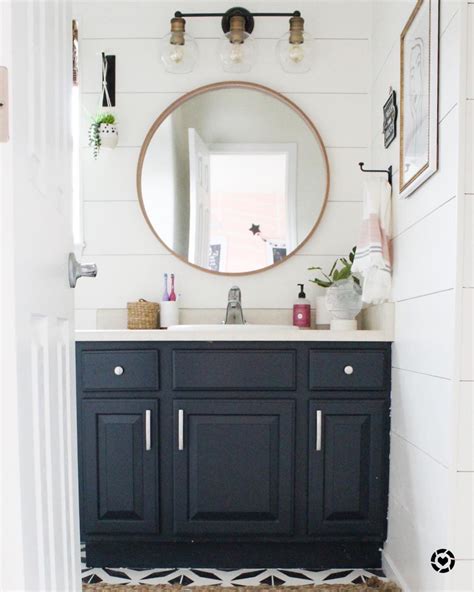 A Bathroom With Black Cabinets And White Walls