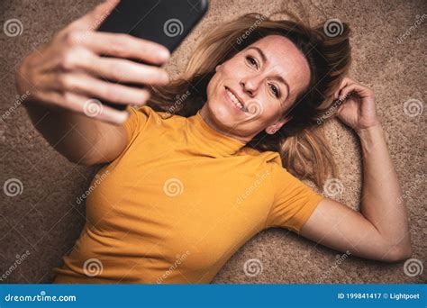 happy middle aged woman taking selfie with her smart phone stock image image of home selfi