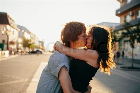 junges paar küssen über sonnenuntergang stockfoto colourbox