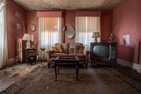 An Old Living Room With Red Walls And Furniture In The Corner