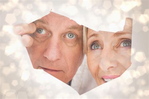premium photo older couple looking through rip against light glowing dots design pattern