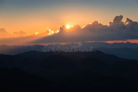 Sunset Shining Through Cloud Over Mountain Range In Tropical Rainforest