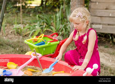 Little Blond Girl Playing In Sandpit On The Playground Stock Photo Alamy