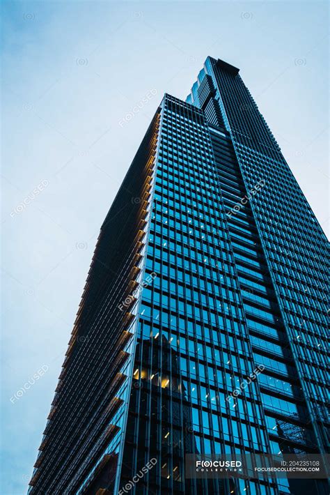 Tall Skyscraper With Glass Walls At Dusk — Vertical Clouds Stock