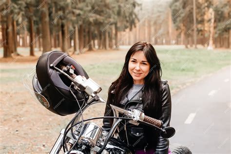 Premium Photo The Beautiful Brunette Riding A Motorcycle In The Park