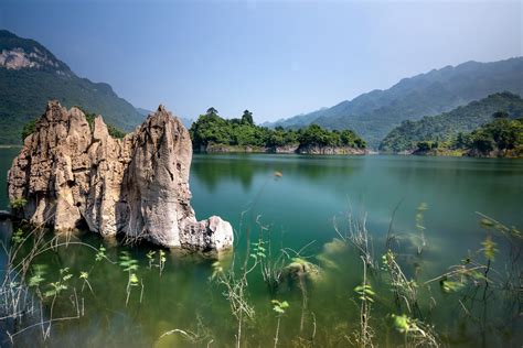 Breathtaking Landscape Of Lake With Rocks Near Green Hills · Free Stock