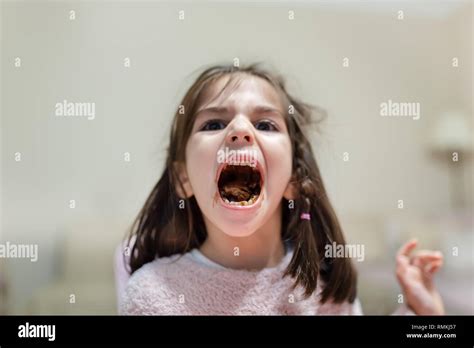 Little Cute Girl Opens Her Big Mouth And Shows Chewed Eats Chocolate