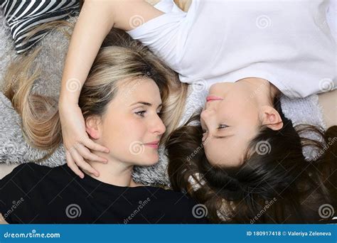 Beautiful Young Mother And Daughter Look At Each Other While Lying On The Bed Happy Motherhood