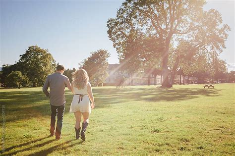 Young Couple Walking Hand In Hand In The Park By Shelly Perry Stocksy