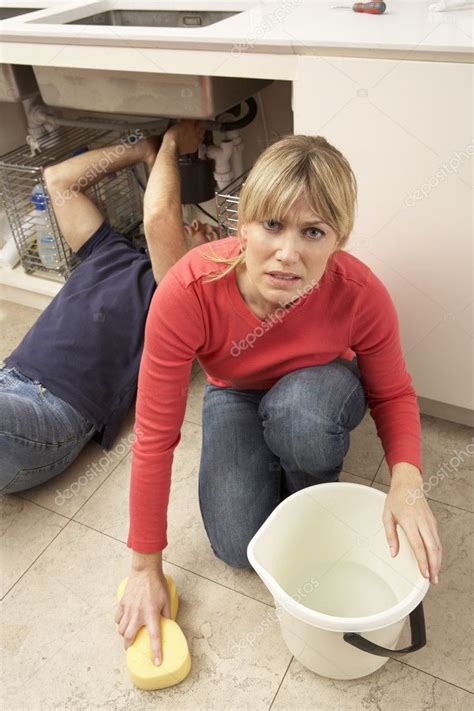 Woman Mopping Up Leaking Sink Whilst Plumber Works Stock Photo By