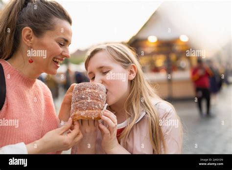 Smiling Modern Mother And Daughter At The Fair In The City Eating