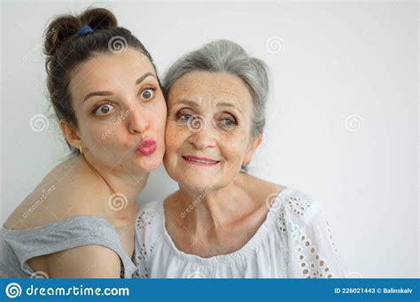 happy senior mother is hugging her adult daughter the women are laughing together sincere