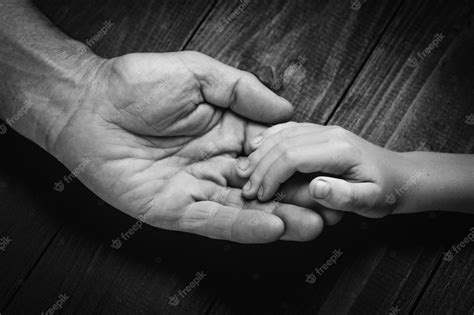 Premium Photo Hands Of An Elderly Man Holding The Hand Of A Younger