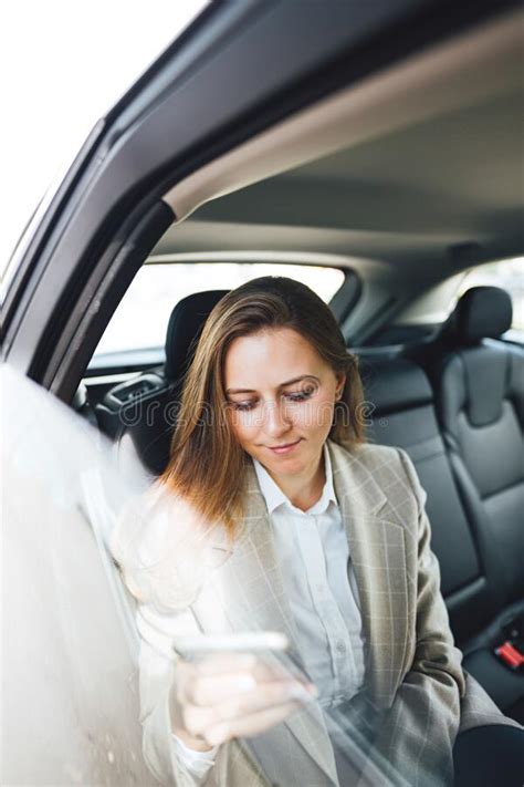 Beautiful Business Woman Using Smartphone While Traveling By Cab Stock