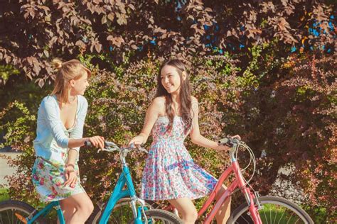 Les Deux Jeunes Filles Avec Des Bicyclettes En Parc Image Stock Image