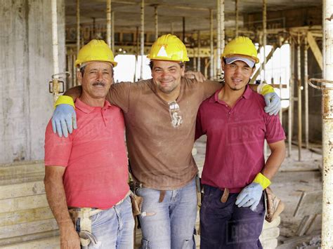 Hispanic Workers Hugging On Construction Site Stock Photo Dissolve