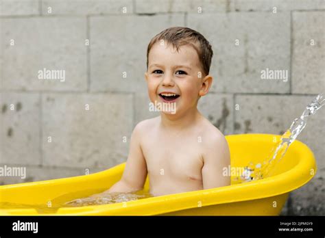 Cute Little Boy Bathing In Yellow Tub Outdoors Happy Child Is