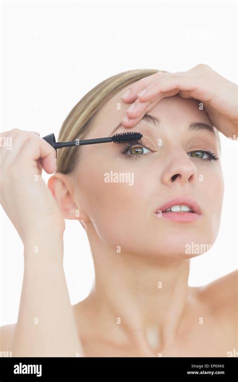 Closeup Portrait Of Young Woman Applying Mascara To Her Eye Stock Photo