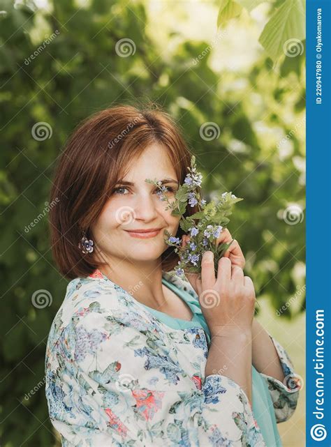 A Pretty Young Woman With A Little Bouquet Of Wildflowers In The Summer In Nature Close Up