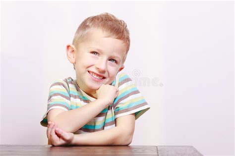 Portrait Of Happy Laughing Blond Boy Child Kid At The Table Stock Photo