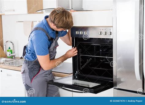 Repairman With Screwdriver Fixing Oven Stock Photo Image Of Kitchen