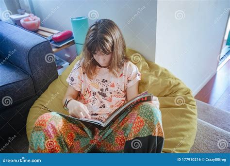 Indoor Portrait Of Young Girl Reading At Home Home Schooling Stock