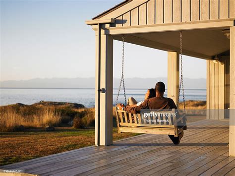 Couple Sitting On Porch Swing Overlooking Water Dusk Rear View Photo Getty Images