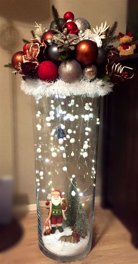 A Glass Vase Filled With Christmas Decorations And Lights